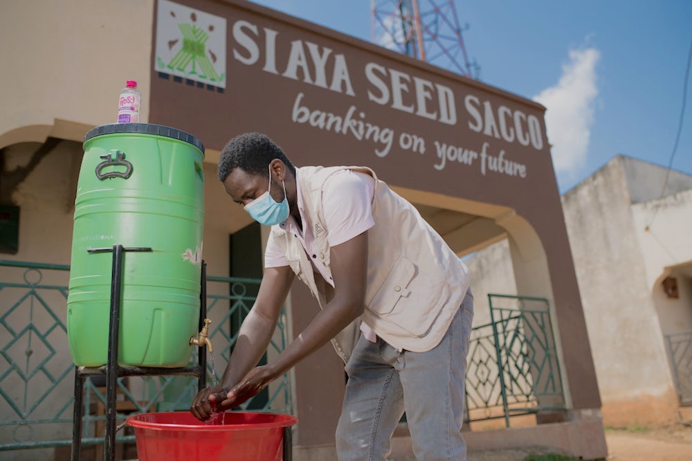 A Kenyan man washes his hands at a hygiene station.