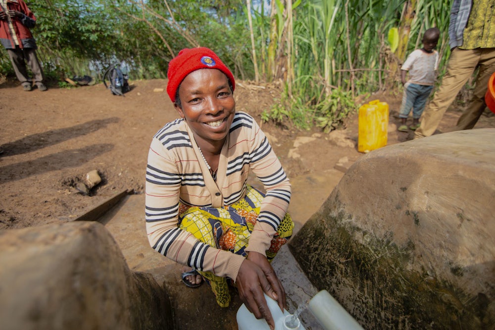 A woman collects water from a water point in Rwanda.