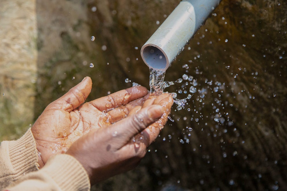 Water splashes over a pair of hands.