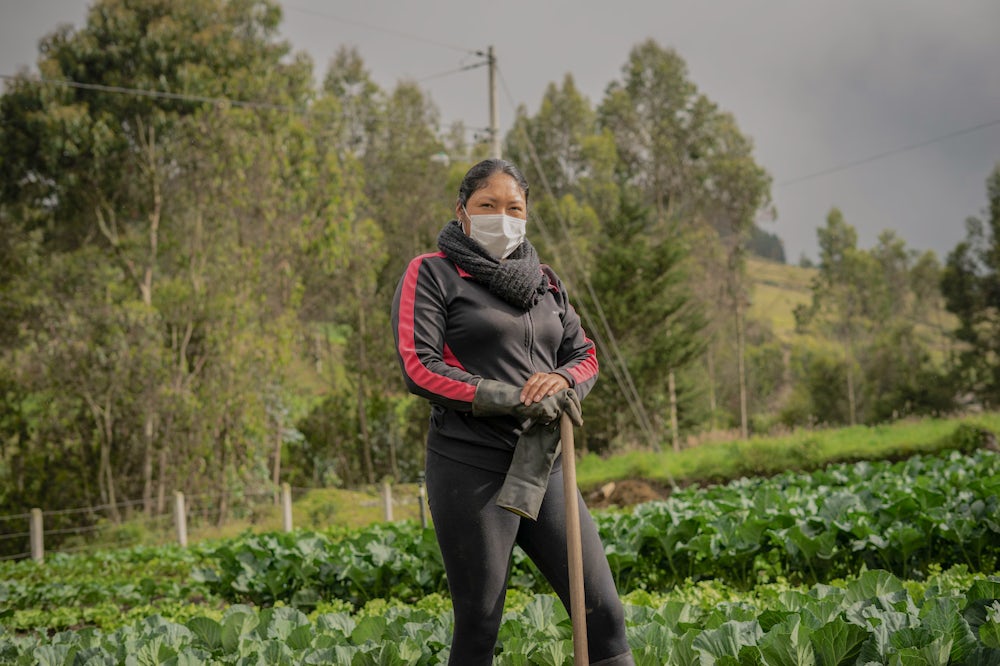 A female Ecuadorian farmer stands for a portrait in her garden.