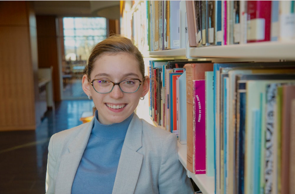 A girl standing in a library.
