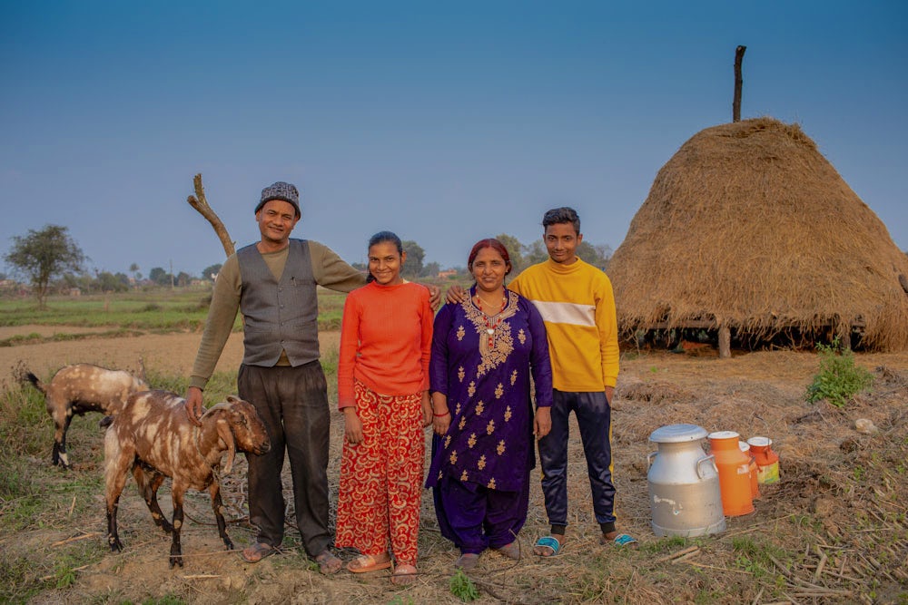 A Nepali family stands in front of their house.