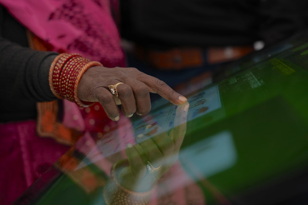 A close up shot of a woman using a touchscreen.