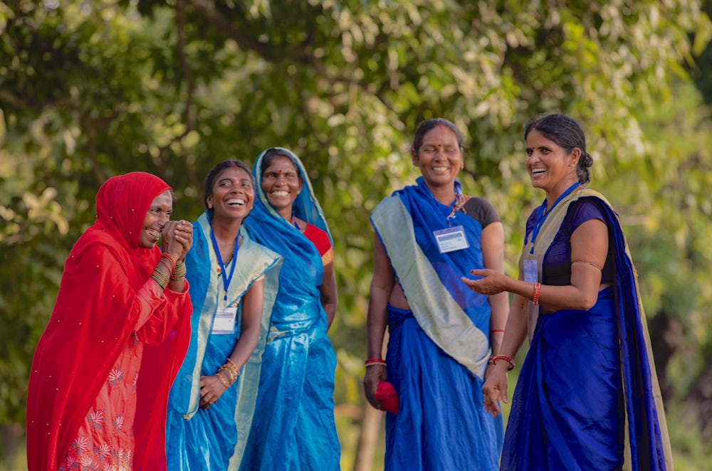 Four women laugh together in India.