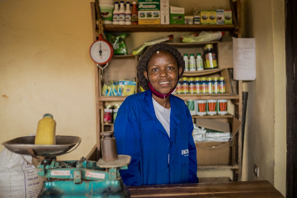 A girl stands at the front desk of a shop in Rwanda.