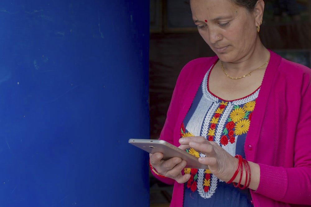 A woman holding a phone and going through a training.