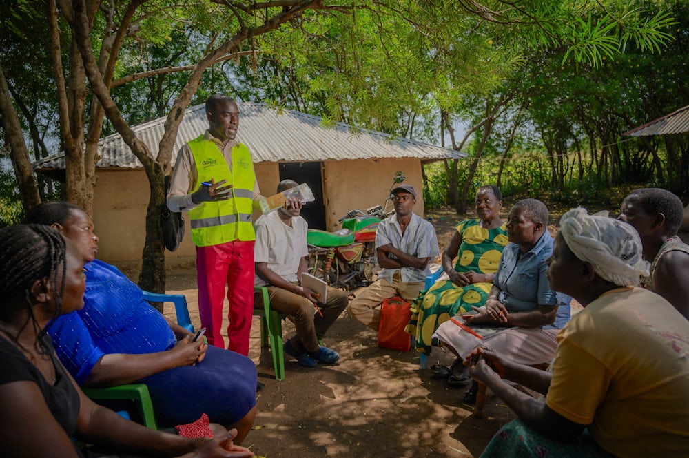 A group of farmers listen to a training in Kenya.