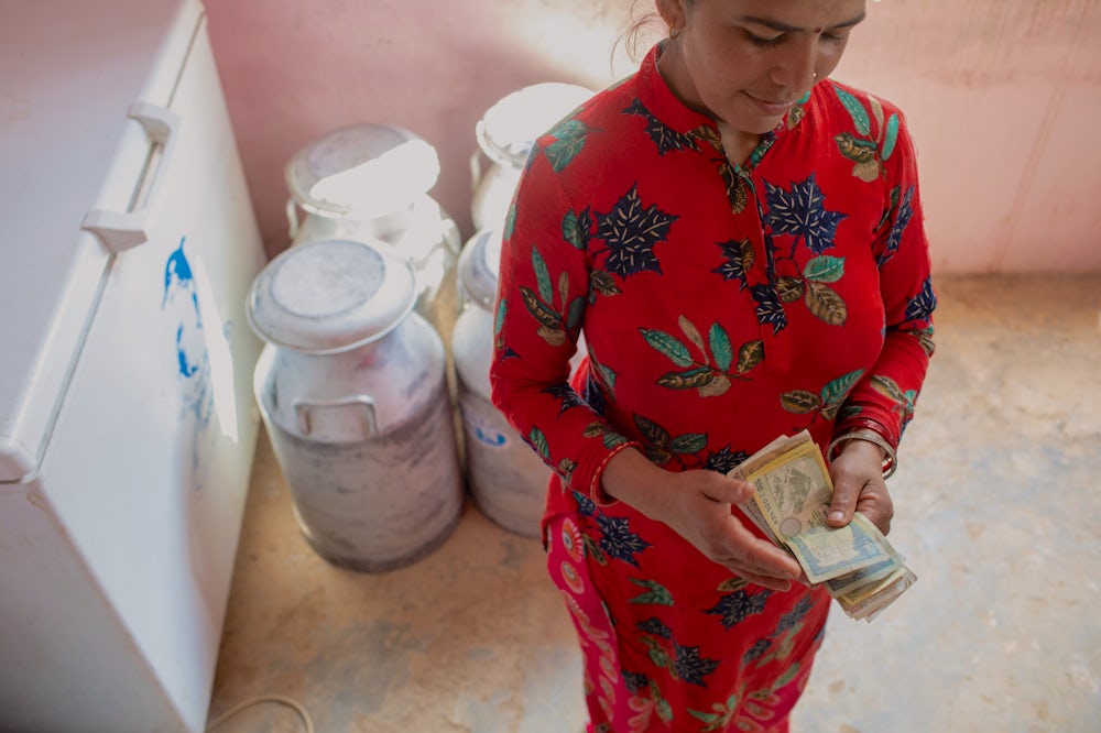 A woman in Nepal counts money.