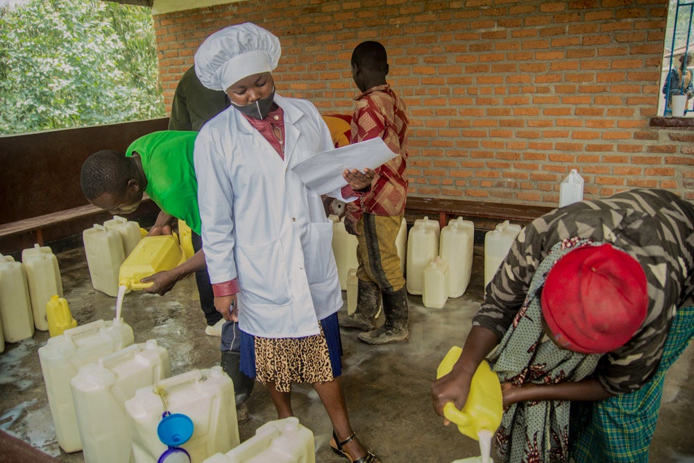 Dairy farmers deliver milk to a milk collection facility in Rwanda.