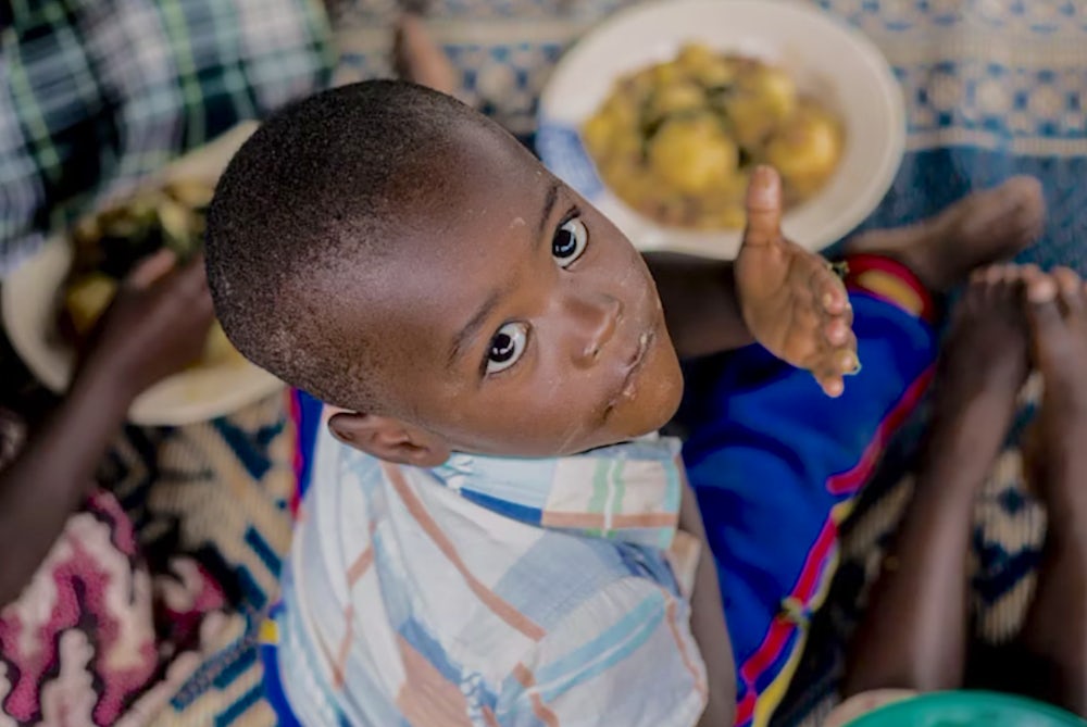 Children enjoy a hearty meal at a community kitchen in Rwanda.