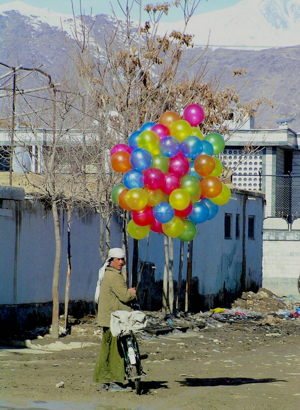 This man in Kabul travels through the neighborhoods of the city on his bicycle selling balloons to children.