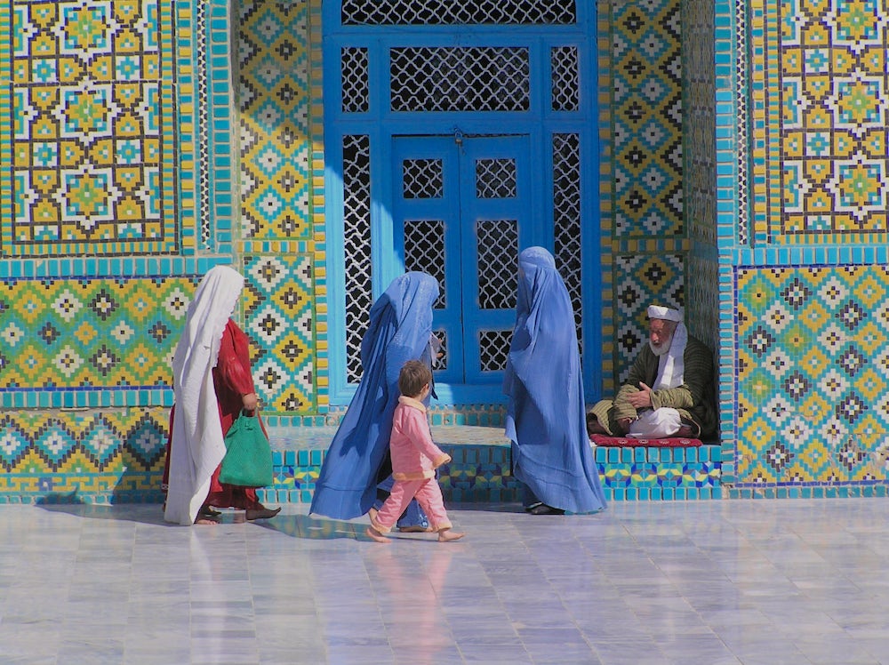 Afghan women wearing burqas at the Blue Mosque in Mazar e Sharif. In the Taliban time, wearing the burqa was compulsory. Though no longer officially enforced, many women still observe the tradition (caption and photo by David Sherman).
