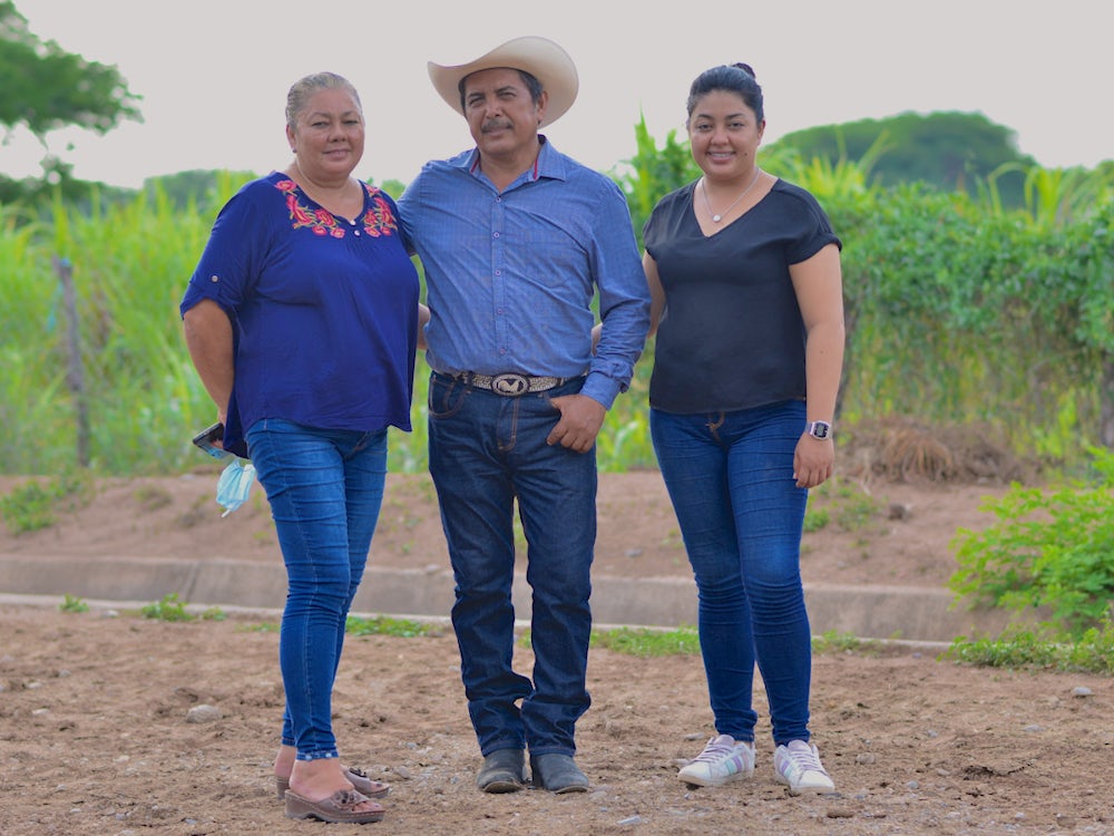 A cattle farming family poses for a photo in rural Mexico.