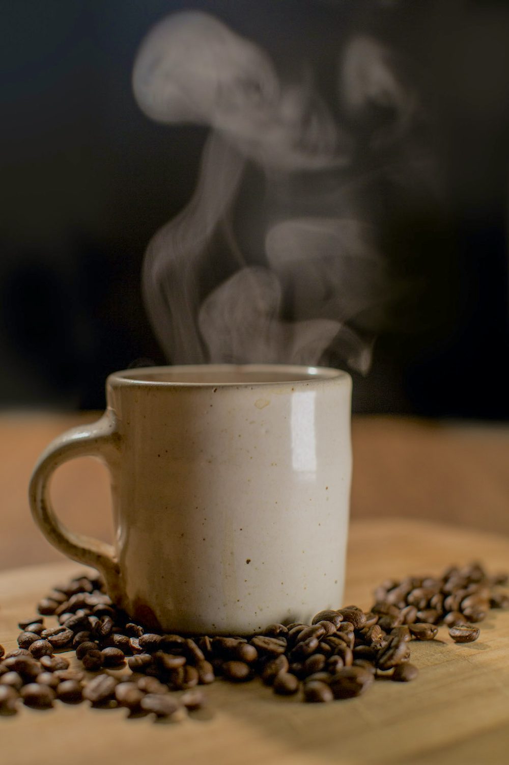 A steaming cup of coffee sits on a table.