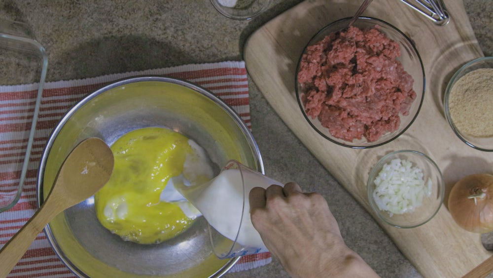 Liz Ellis mixes meatloaf ingredients together. You can see the full process in the video above!