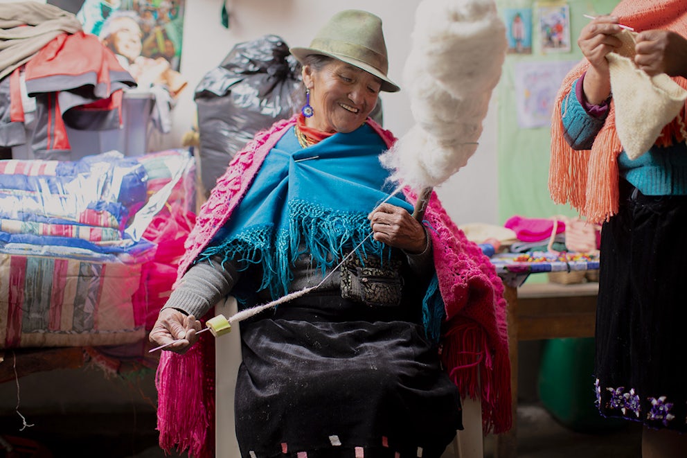 A woman spins alpaca fiber into yarn