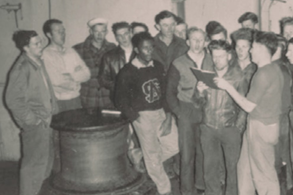 Seagoing cowboys carol aboard their ship during the holidays.
