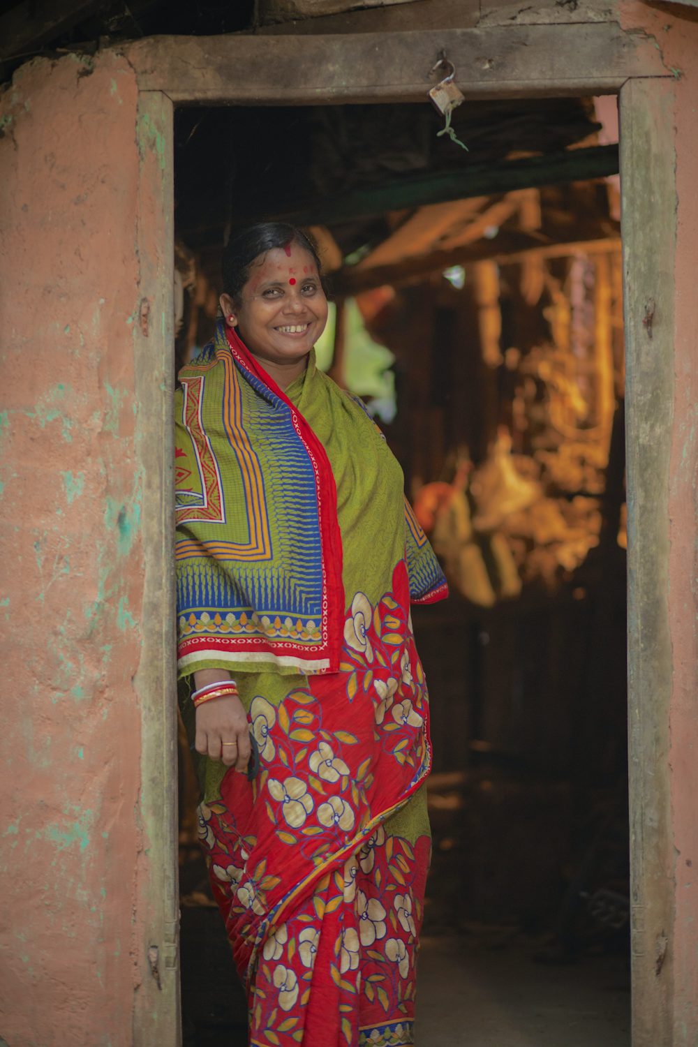 Geeta Rani Jena stands in the doorway of her home in Odisha, India. 