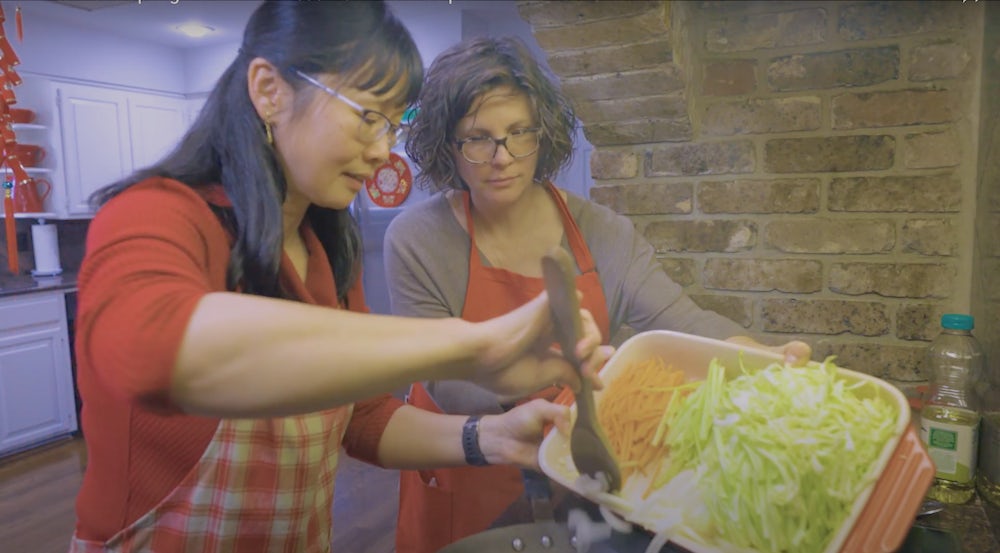 Annie Bergman Giattina Adds julienned vegetables to a hot wok while Pooi Yin Chong stirs. 