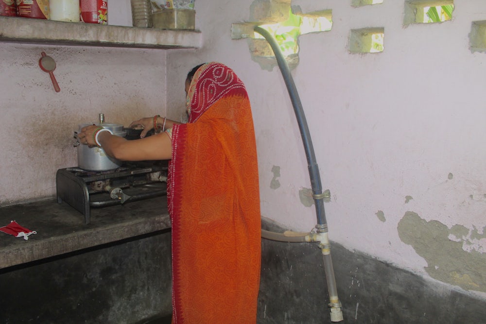 A woman in India cooks at her stove.