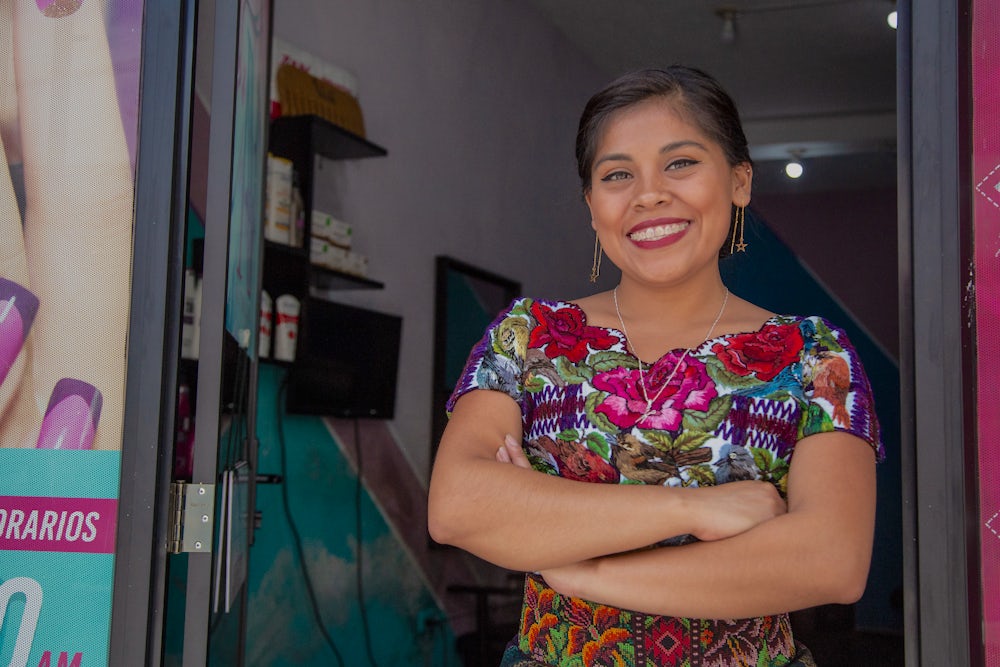 Nataly Mendoza Quieju stands at the entrance of her salon. Photo by Phil Davis.