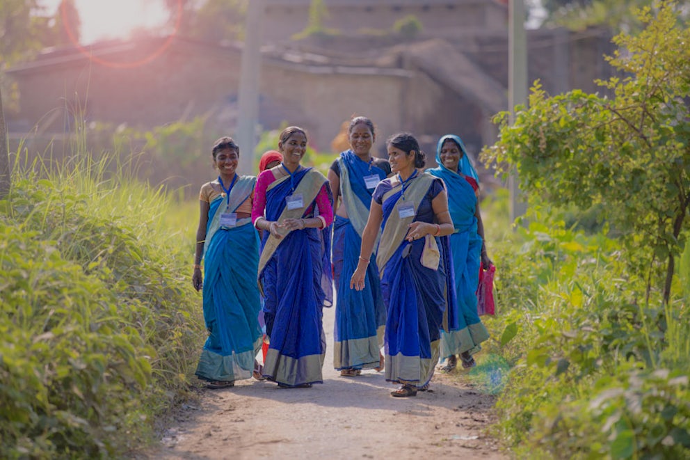 A group of women walking in the field.