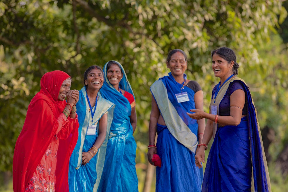 A group of women laughing and talking to each other.