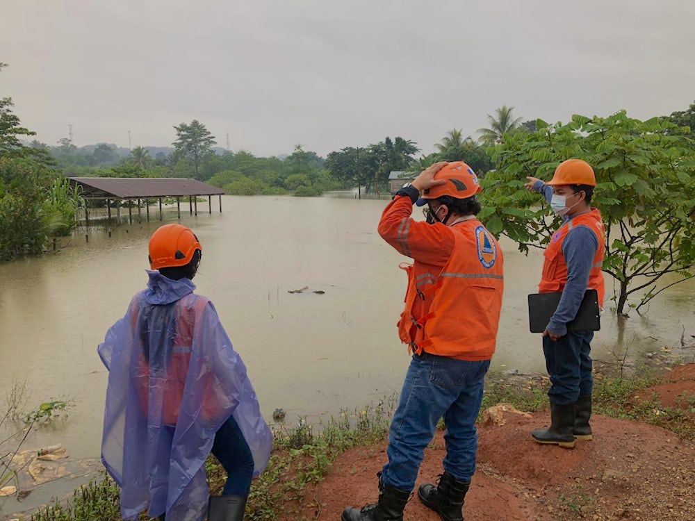 Emergency workers survey flooding in Chisec, Guatemala.