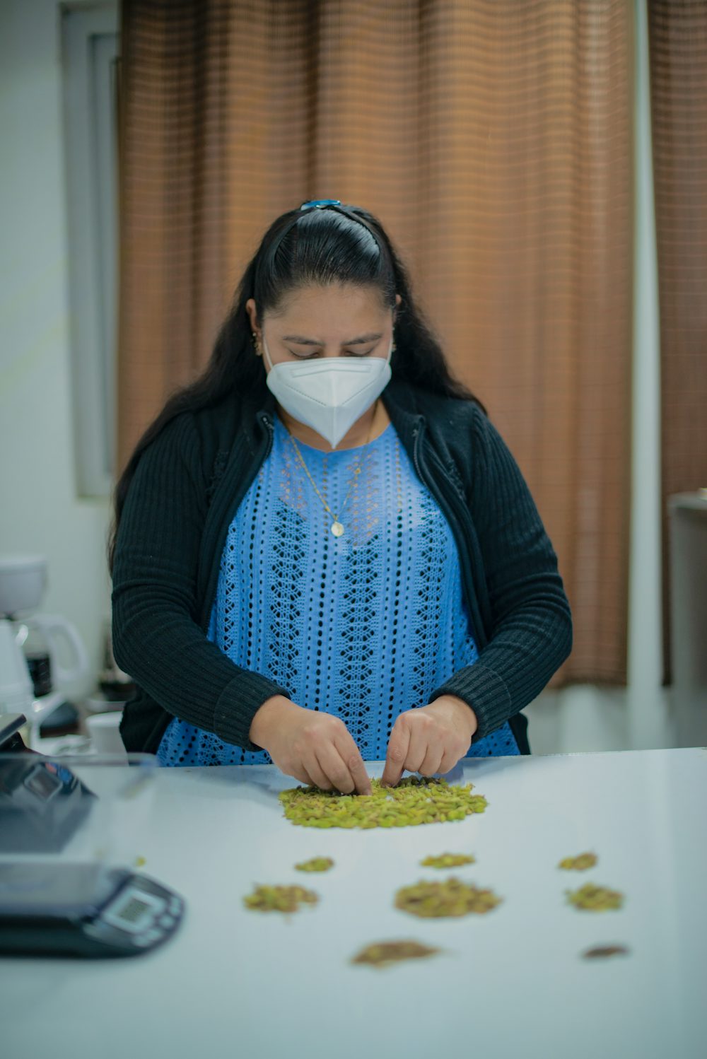 A woman sorts cardamom inside a spice distribution company in Guatemala.