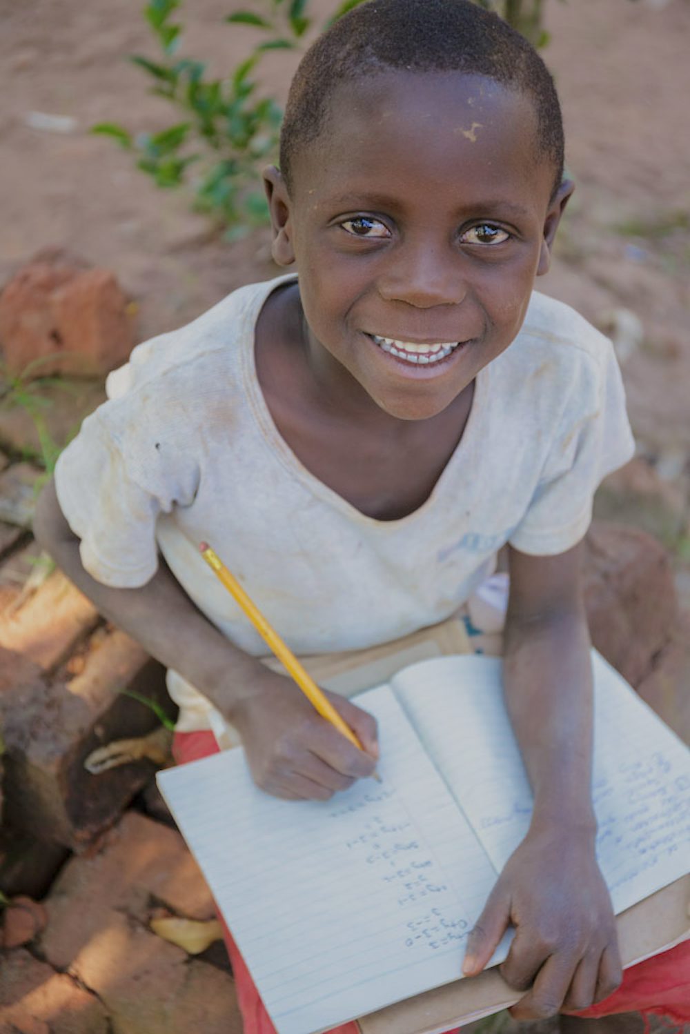 A boy sits with his homework.