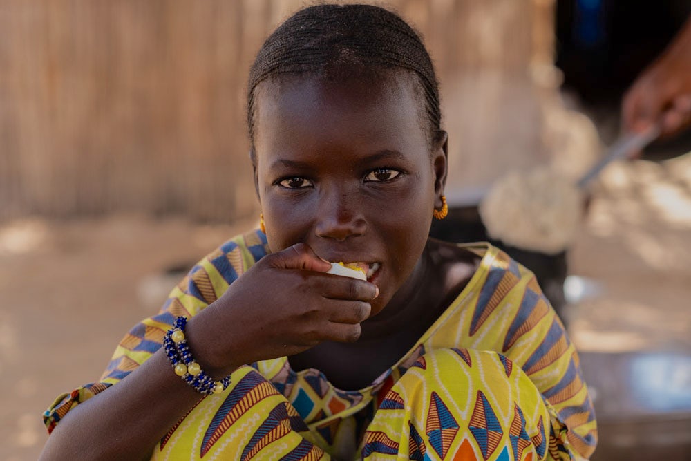 A girl eats an egg.