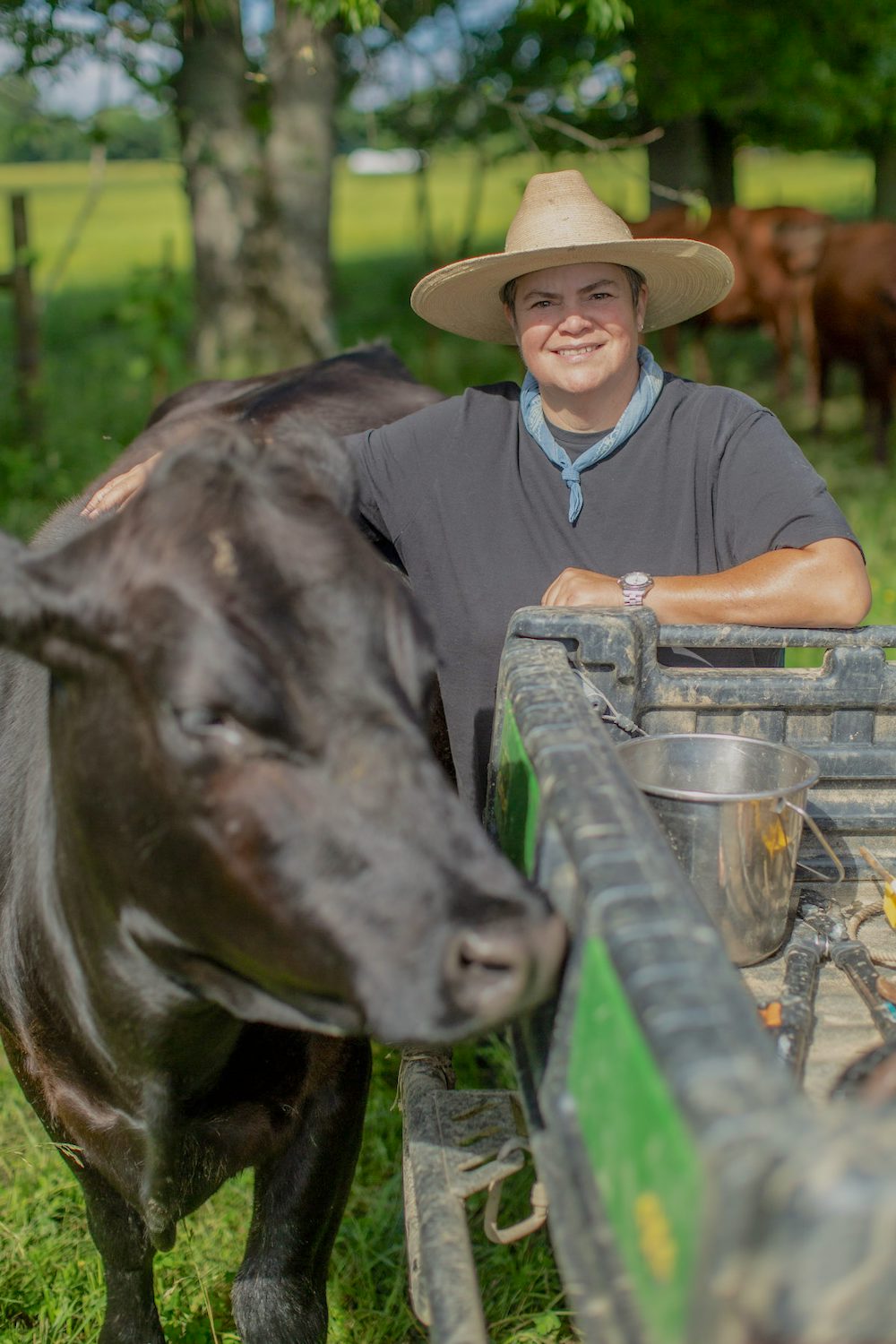 Donna Kilpatrick stands with a large, black cow. 