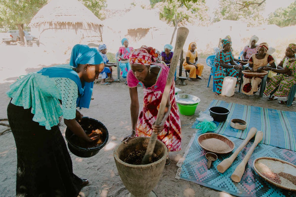 Grinding and preparing the nutrient-dense flour for their children is a social event. Photo by Lacey West.