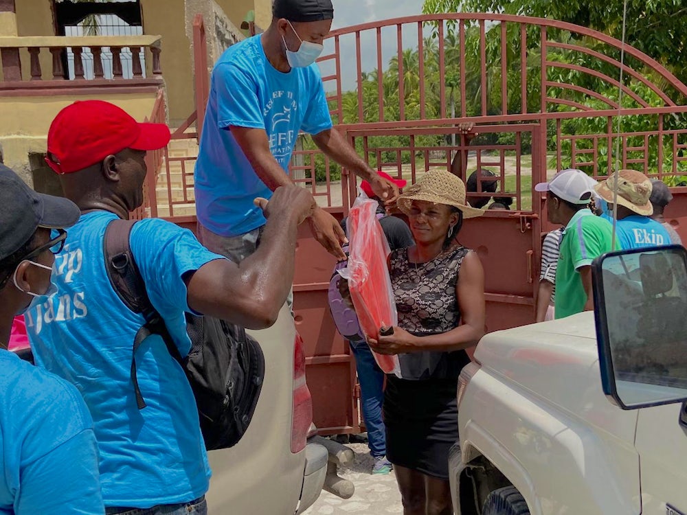Heifer staff distribute tarps to Haiti residents.