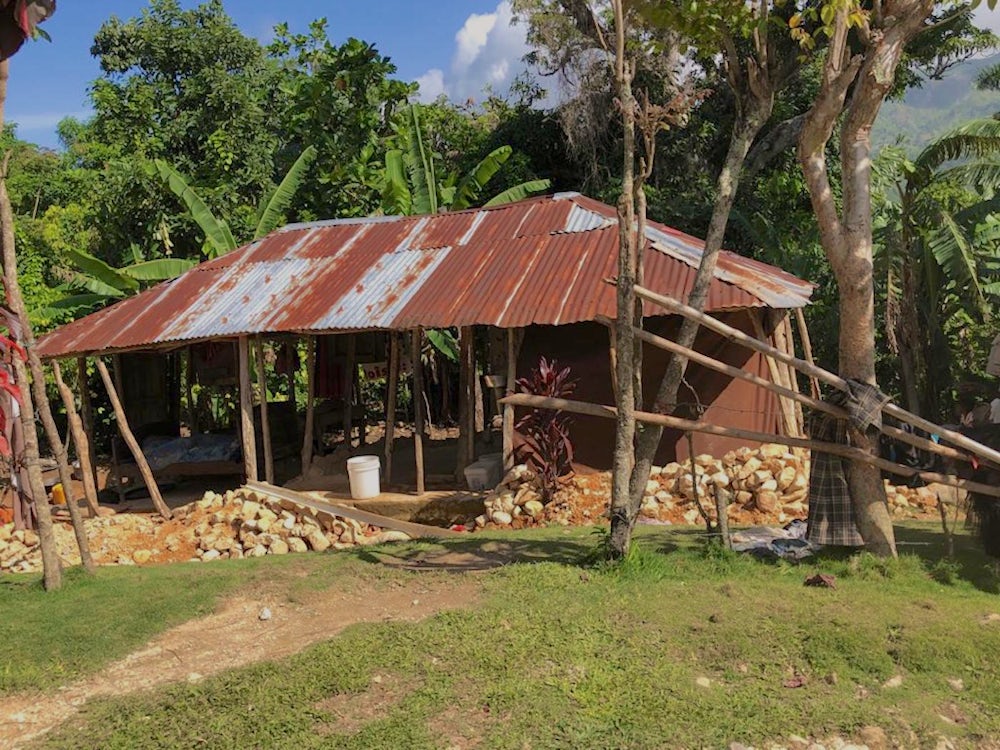 A house in Haiti damaged by the earthquake shows piles of bricks lying on the ground.