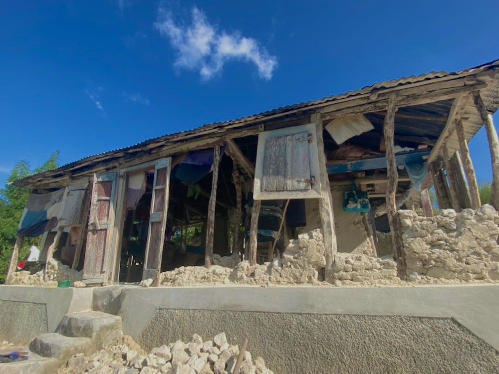 Another house shows extensive damage due to the earthquake.