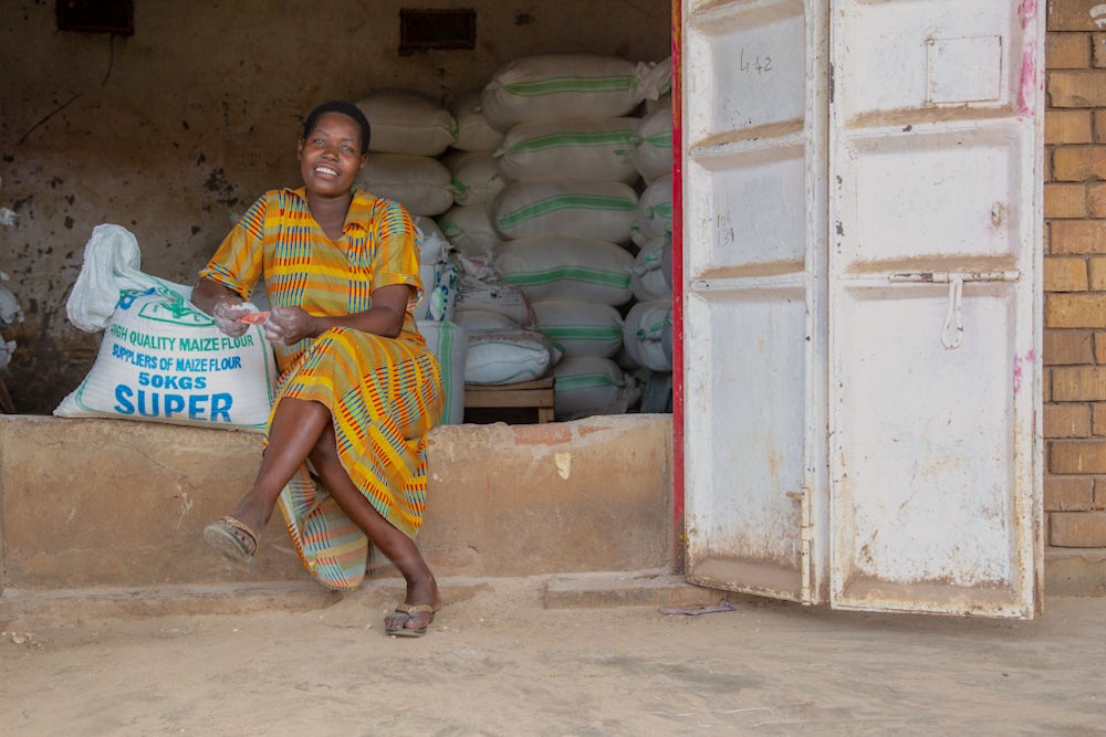 A young woman sits in the doorway of her shop.