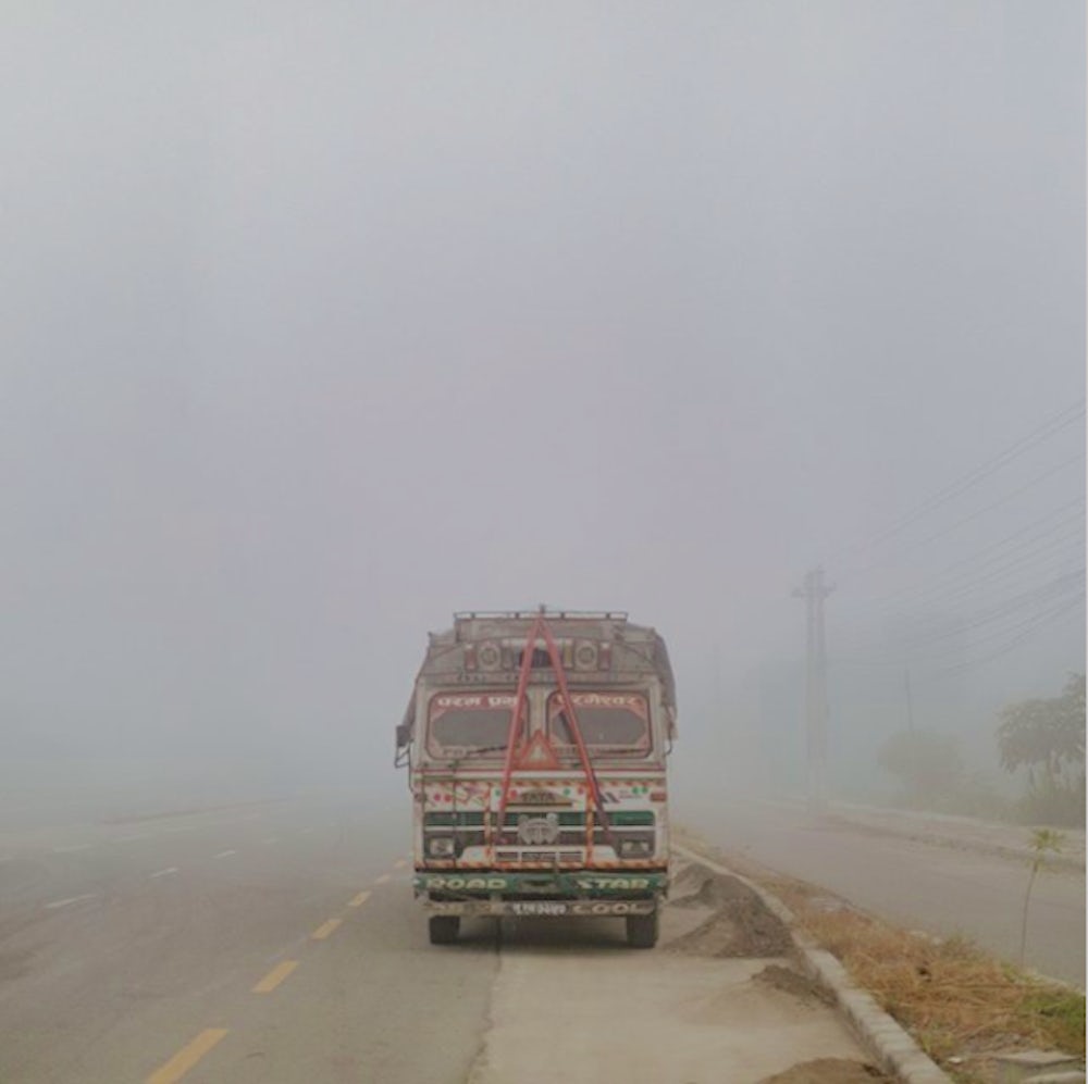 A highly decorated bus sits alongside a roadway outside Kathmandu, Nepal