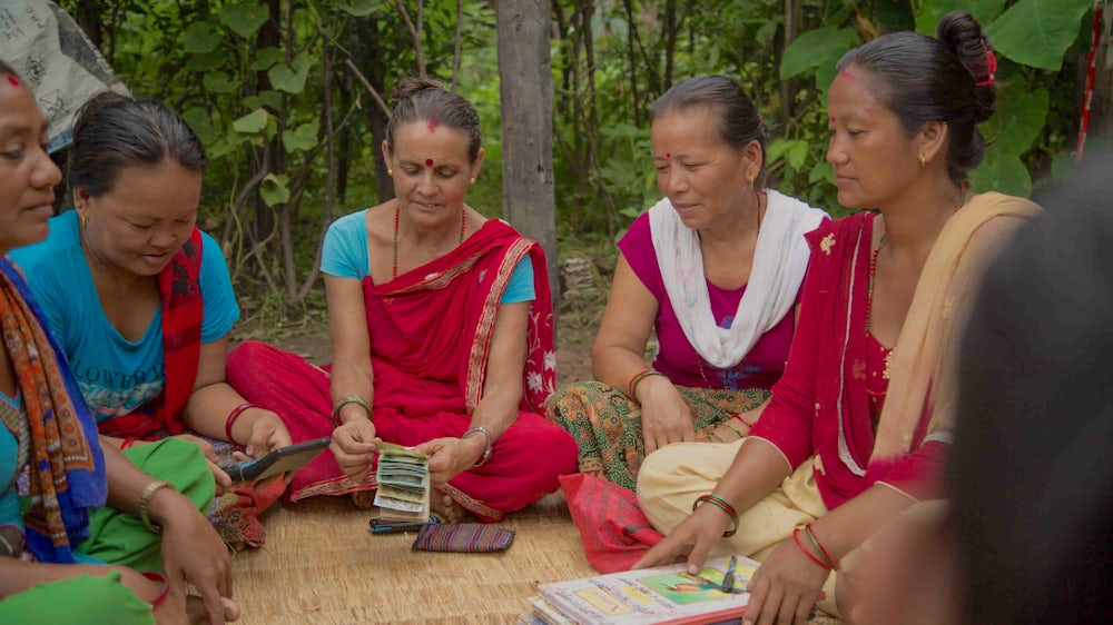 Members of the Sangam Women's Self-help Group in Nepal gather together discuss business and count their savings.