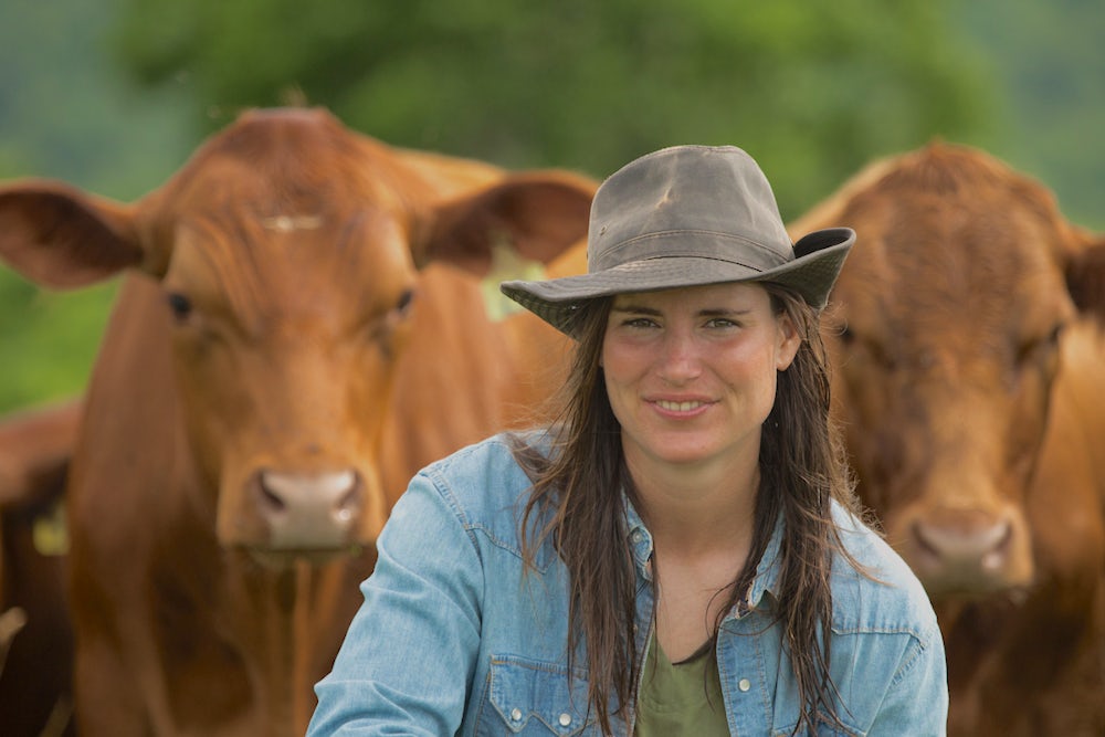 woman in front of herd of cows